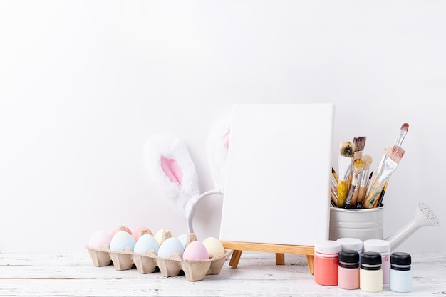 Huevos de Pascua de color pastel y flores de mimosa con marco blanco en blanco para la vista frontal del diseño de la maqueta sobre fondo de pared de ladrillo blanco