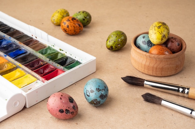 Huevos de Pascua para colorear. Pinturas, pinceles, huevos de codorniz sobre un fondo de elaboración. Preparación para la celebración de la Pascua, decoraciones para la fiesta, fondo. Concepto creativo.