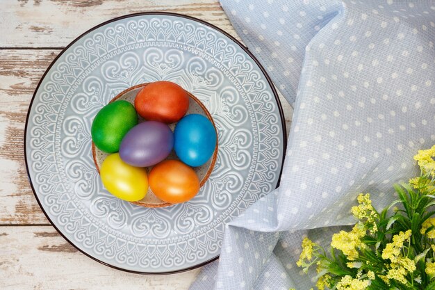 Huevos de Pascua de colores brillantes en un plato con un adorno