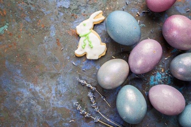 Huevos de pascua de colores pastel sobre fondo de piedra oscura con espacio para la vista superior del texto