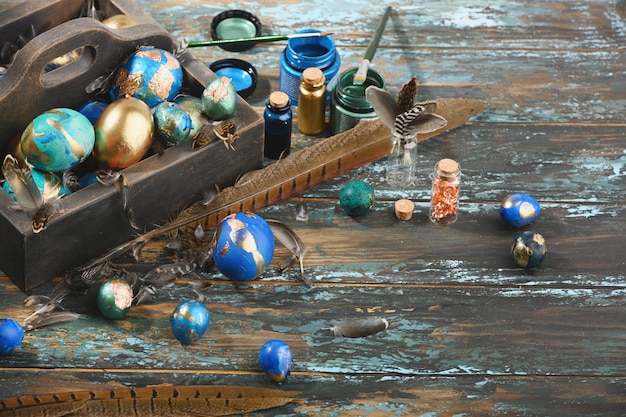 Huevos de Pascua de colores pintados en caja de madera oscura sobre fondo de madera oscura Estilo boho