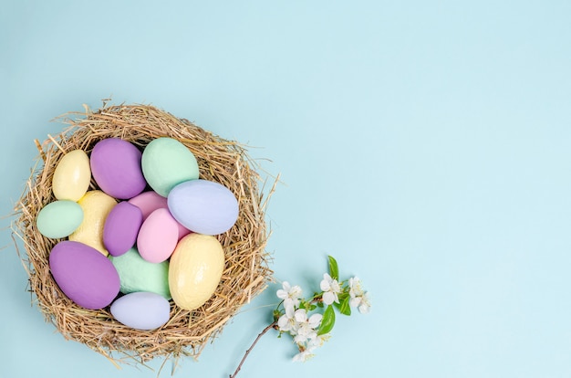 Huevos de Pascua de colores sobre un fondo azul. Concepto de estacionalidad, primavera, postal, vacaciones. Lay Flat, copia espacio, espacio para texto. Vista desde arriba