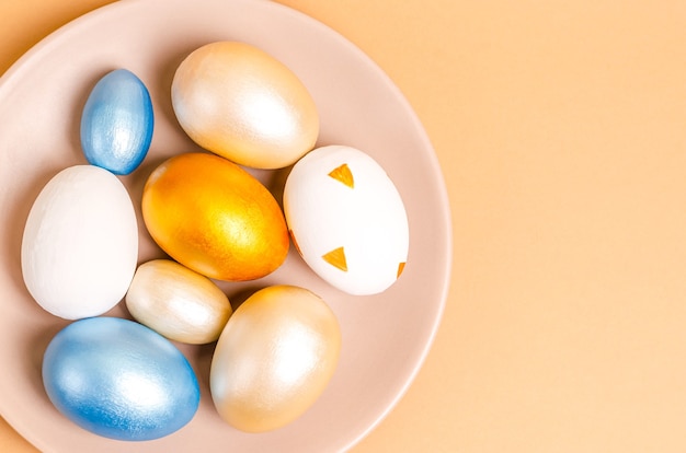 Huevos de Pascua de colores sobre un rallador sobre un fondo beige. Endecha plana, postal en blanco, espacio para texto, espacio de copia. Vista desde arriba.