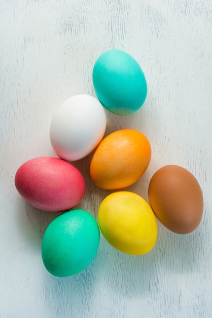 Huevos de Pascua de colores sobre superficie blanca de madera