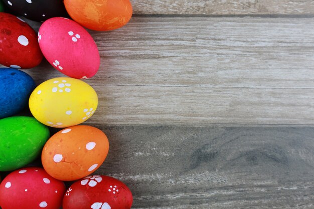 Huevos de Pascua coloridos y decorados en mesa de madera vintage