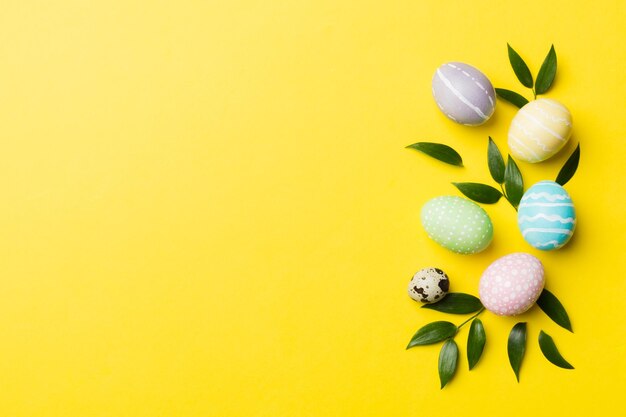 Huevos de Pascua coloridos con hojas de flores de primavera aisladas sobre fondo blanco Borde de vacaciones de huevo de color