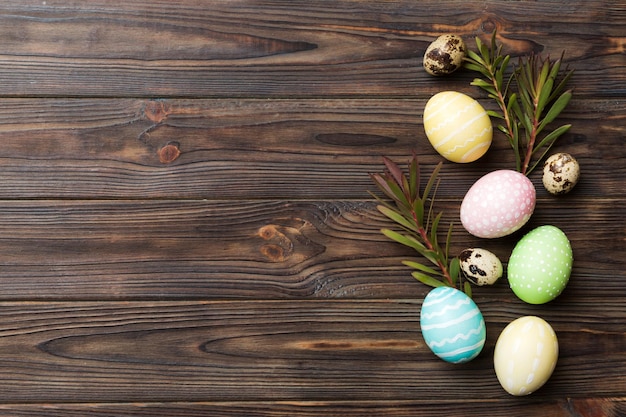 Huevos de Pascua coloridos con hojas de flores de primavera aisladas sobre fondo blanco Borde de vacaciones de huevo de color