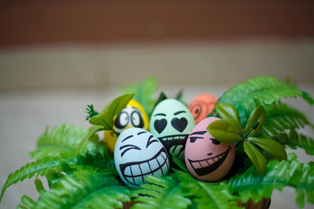 Huevos de pascua coloridos perfectos hechos a mano con planta verde aislado en un fondo marrón Conceptos del día de Pascua Decoración divertida Felices Pascuas