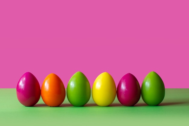 Huevos de pascua coloridos en una primavera de fondo rosa