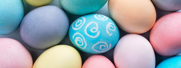 Huevos de Pascua coloridos teñidos con agua coloreada con un patrón hermoso en un concepto de diseño de fondo azul pálido de actividad navideña vista superior de marco completo