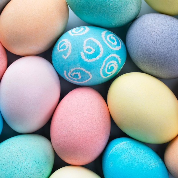 Huevos de Pascua coloridos teñidos con agua coloreada con un patrón hermoso en un concepto de diseño de fondo azul pálido de actividad navideña vista superior de marco completo