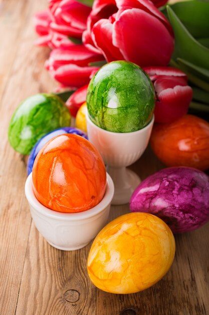 Huevos de Pascua coloridos y tulipanes rosados