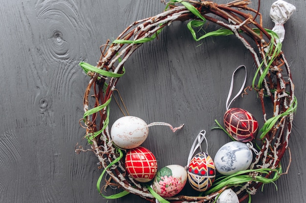 Huevos de Pascua y corona sobre un fondo de madera