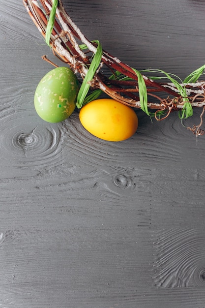 Huevos de Pascua y corona sobre un fondo de madera