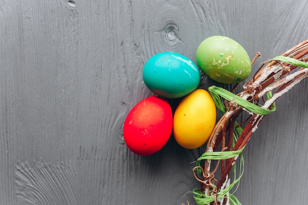 Huevos de Pascua y corona sobre un fondo de madera