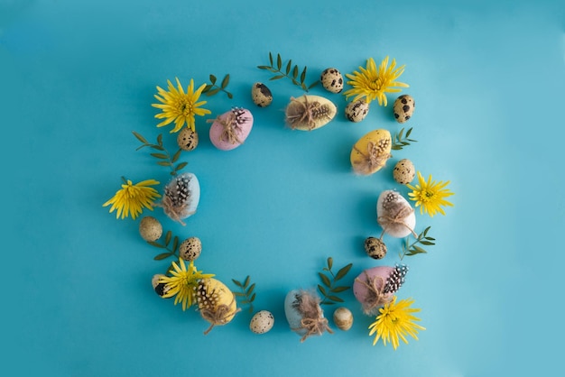 Huevos de Pascua decorados y huevos manchados de codorniz en decoración de primavera en un espacio de copia de fondo azul