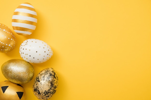 Huevos de Pascua decorados de oro sobre fondo amarillo