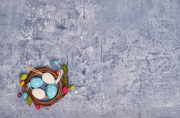 Huevos de Pascua decorativos en nido pequeño.