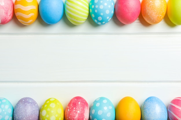 Huevos de Pascua decorativos sobre fondo blanco de madera