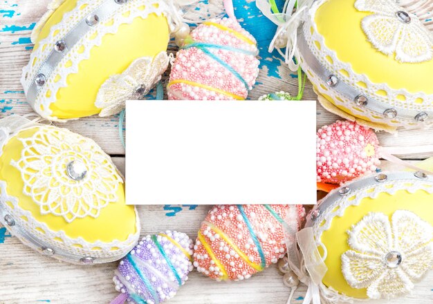 Huevos de pascua decorativos con tarjeta de papel en blanco