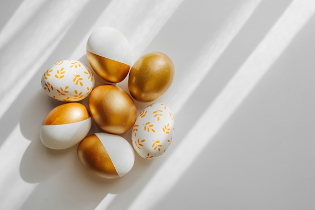 Huevos de Pascua dorados sobre fondo blanco Concepto de vacaciones Tarjeta de Pascua feliz con espacio de copia