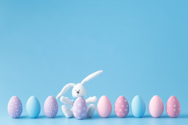 Huevos de Pascua en una fila, sobre fondo azul.