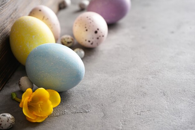 Huevos de Pascua y flor sobre un fondo gris