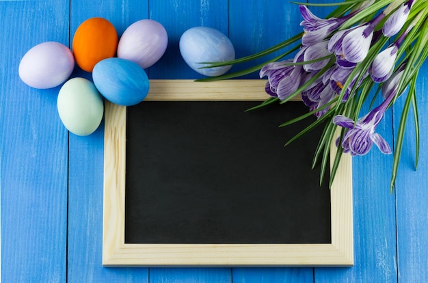 Huevos de pascua con flores y una pizarra con espacio para texto