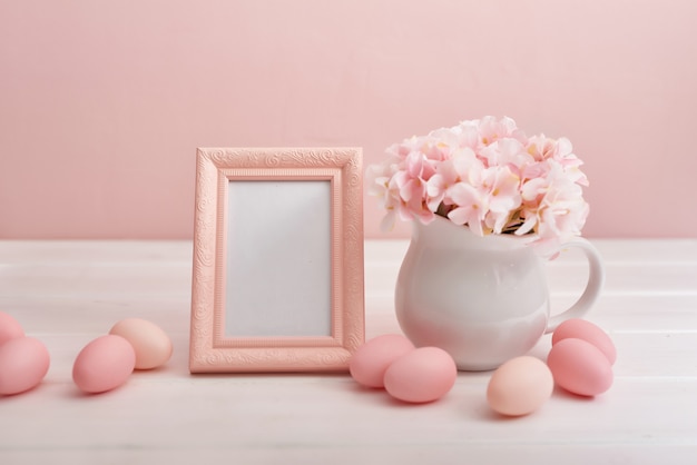 Huevos de Pascua y flores sobre fondo blanco.