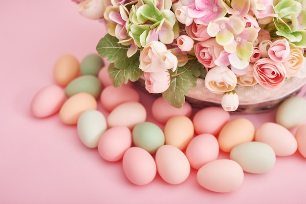 Huevos de Pascua y flores sobre fondo rosa. Decoración de Pascua con huevos.