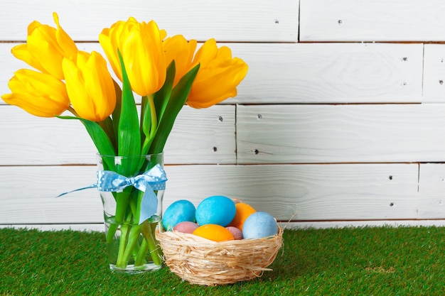 Huevos de Pascua con flores sobre hierba verde