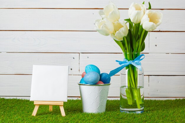 Huevos de Pascua con flores sobre hierba verde