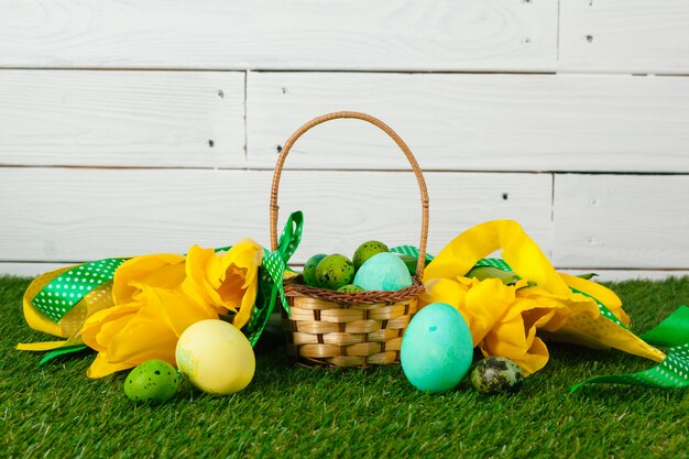 Huevos de Pascua con flores sobre hierba verde