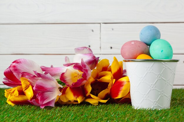 Huevos de Pascua con flores sobre hierba verde