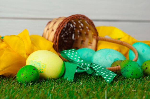 Huevos de Pascua con flores sobre hierba verde