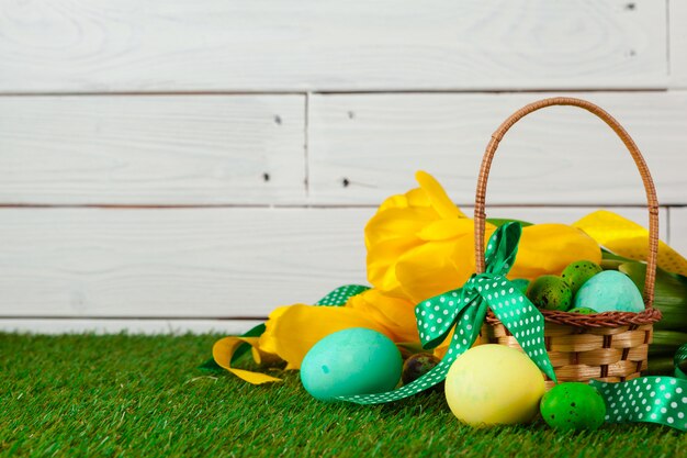 Huevos de Pascua con flores sobre hierba verde