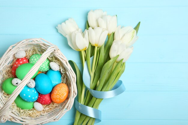 Huevos de Pascua y flores en la vista superior de la mesa
