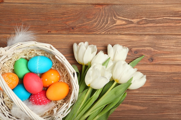 Huevos de Pascua y flores en la vista superior de la mesa