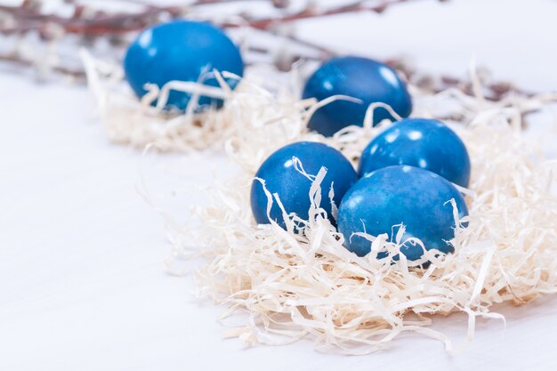 Huevos de Pascua galácticos del espacio azul en nido. De cerca. Tarjeta de felicitación de pascua.