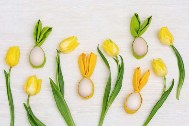 Huevos de Pascua hechos a mano con orejas de conejo y amarillo primavera