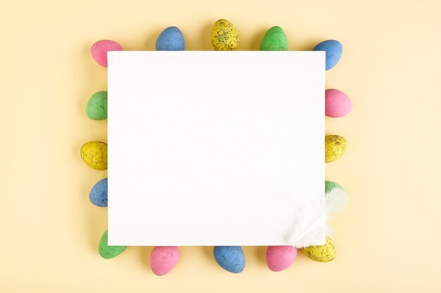 Huevos de Pascua y lienzo en blanco sobre fondo pastel