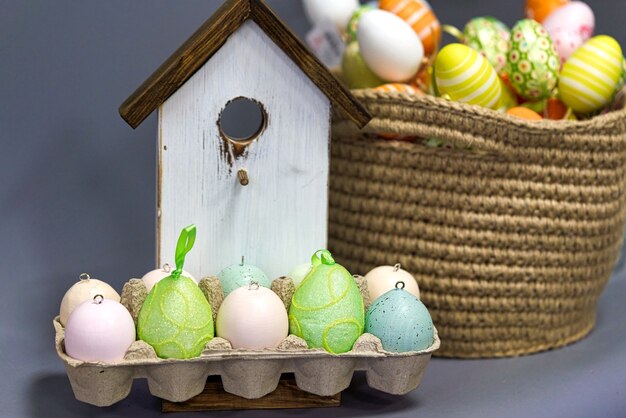 Huevos de Pascua multicolores en el fondo de una casa de pájaros de madera