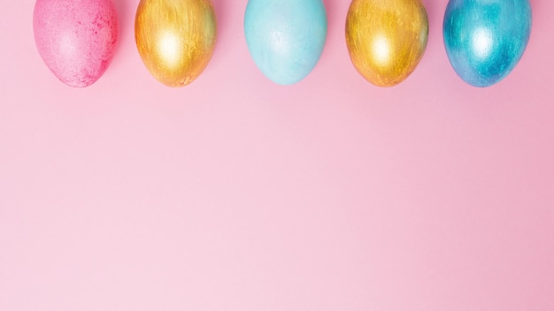 Huevos de Pascua multicolores en una pared de color rosa. Detener el movimiento