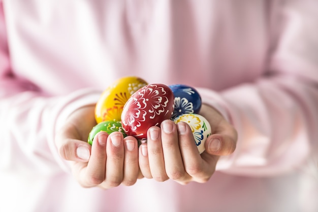 Huevos de Pascua multicolores de primer plano en las manos de las niñas.