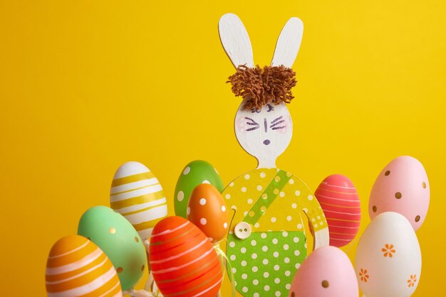 Huevos de pascua multicolores sobre un fondo amarillo vacaciones de pascua