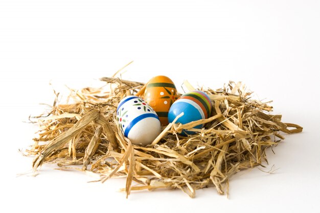 Huevos de Pascua en un nido aislado en la superficie blanca.