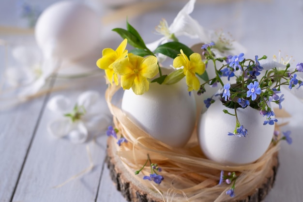 Foto huevos de pascua en un nido con flores.