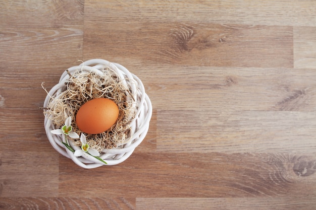 Huevos de Pascua en el nido en la mesa rústica de madera, fondo de vacaciones para su decoración. Concepto de vacaciones de primavera y Pascua con espacio de copia.