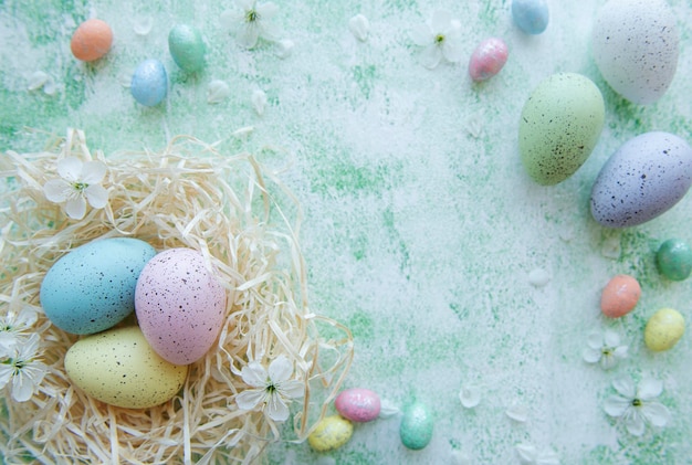 Huevos de Pascua en nido de paja sobre un fondo de madera verde