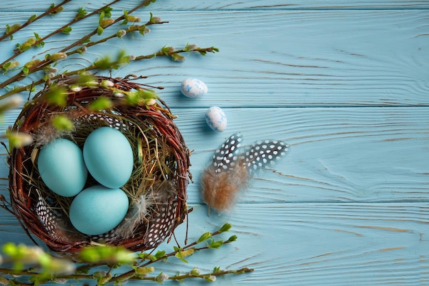 Huevos de pascua en un nido sobre un fondo de madera azul